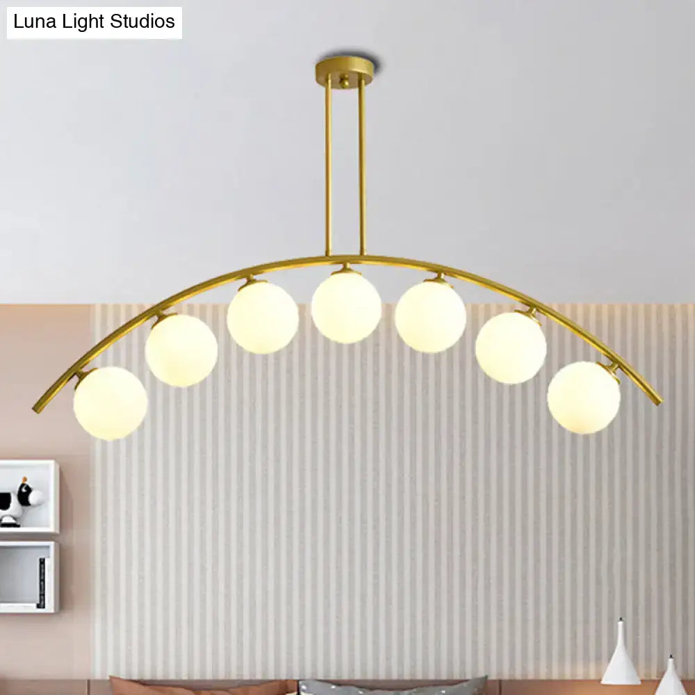 Gold-toned DecorBites island pendant with six spherical frosted bulbs and clear white shade for modern kitchens