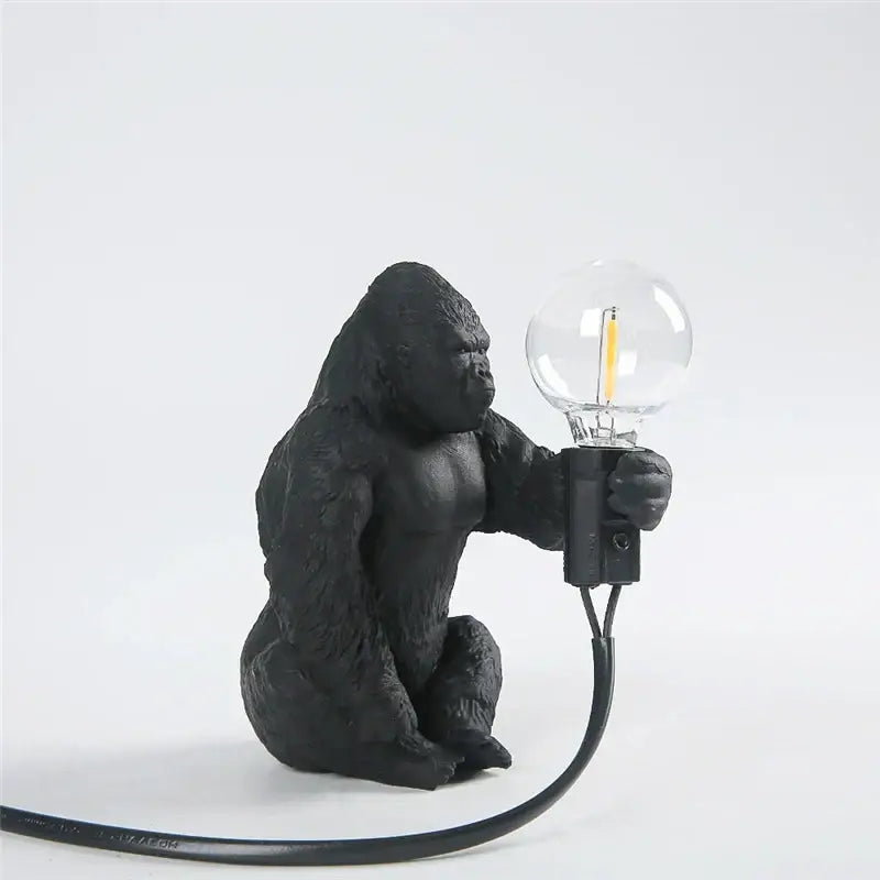 Black gorilla-shaped king kong resin night light with textured matte finish holding clear glass bulb for decorbites decor