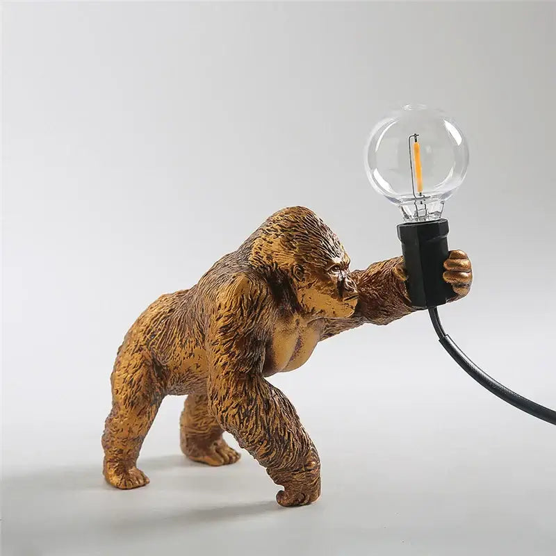 Modern gold king kong resin night light featuring a golden gorilla figurine lamp holding a clear bulb by decorbites king kong