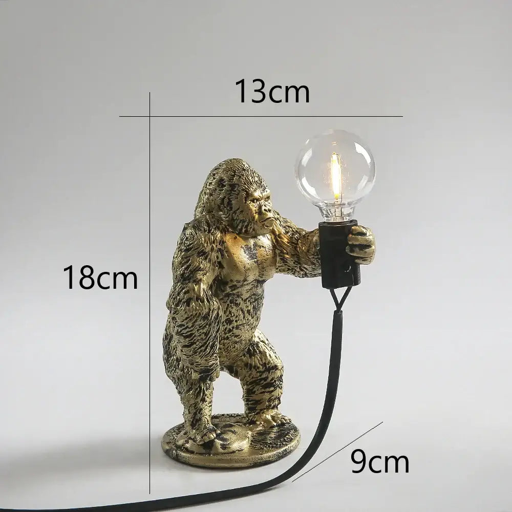 Modern gold king kong resin night light lamp featuring a golden gorilla figurine with clear bulb and black cord decorbites king kong