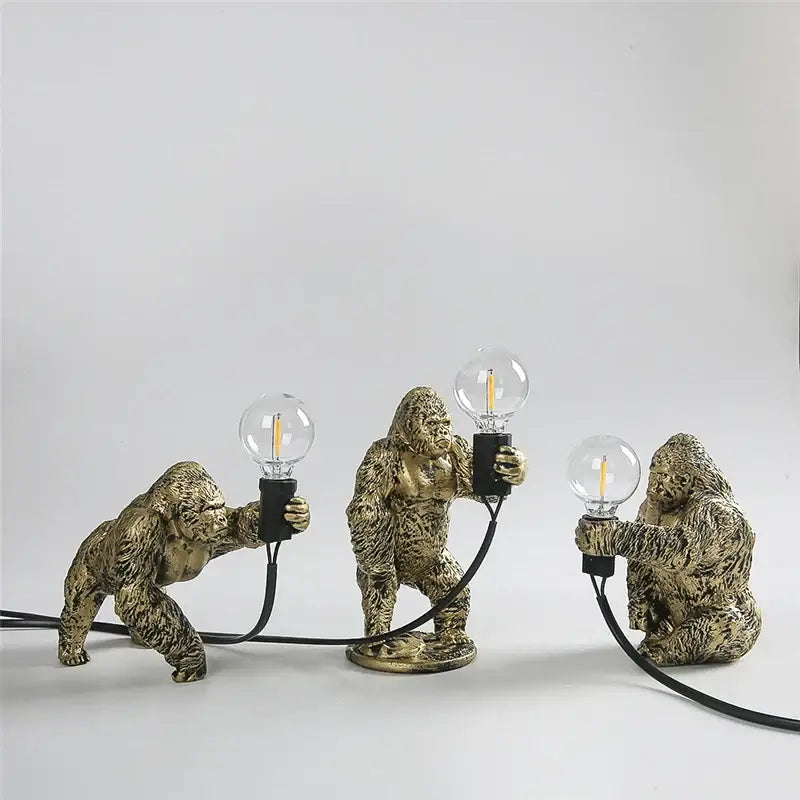 Modern gold king kong resin night light featuring three golden gorilla figurines holding edison bulb decorbites king kong