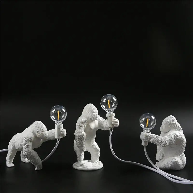 Three white ceramic king kong resin figurines holding glass bulbs in decorbites king kong night light lamp