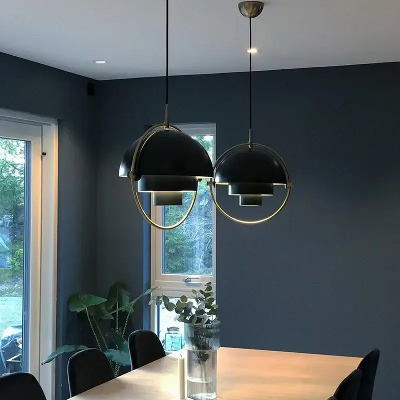 Modern gold layered Danish pendant light with black and brass geometric design hanging above dining table decorbites pendant light