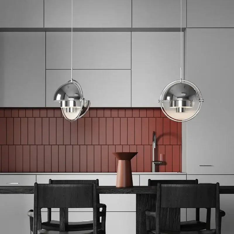 Two chrome spherical danish pendant lights hang above a dining table accenting modern decorbites danish pendant style