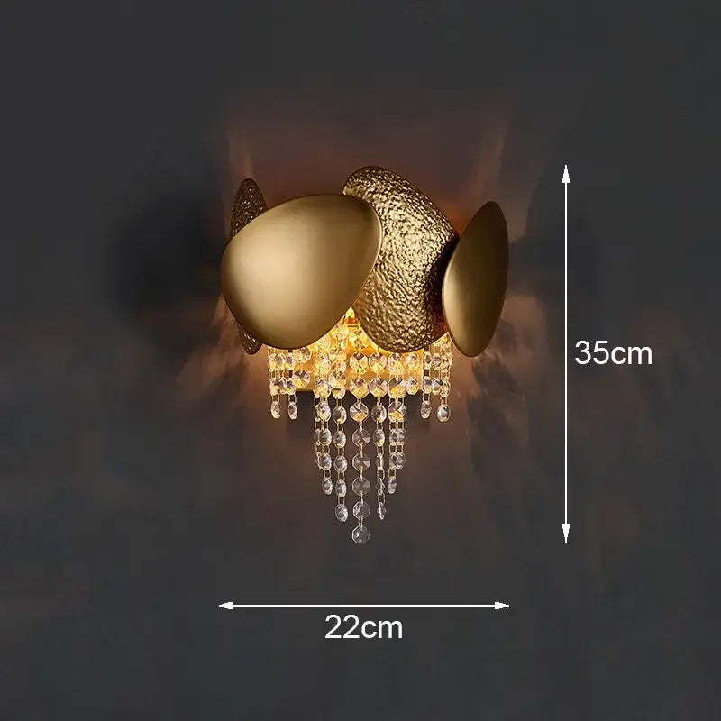 Modern gold leaf crystal wall lamp featuring a gold-toned egg-shaped sconce with dangling decorbites crystal beads