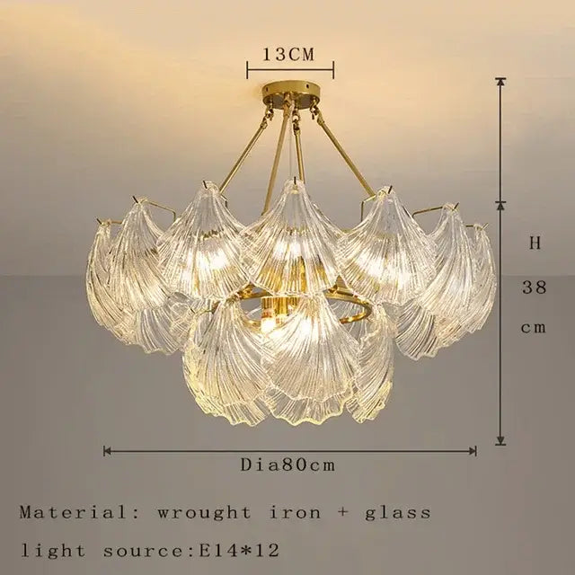 A delicate golden decorbites crystal glass chandelier with intricate leaf shades and wrought iron frame for dining room light