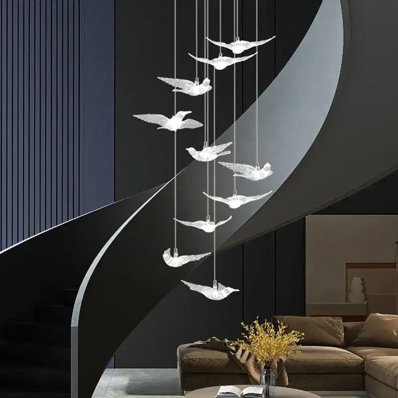 A modern gold led bird pendant light with seven translucent winged birds in cascading design for dining room lighting