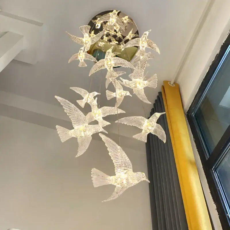 Modern gold led bird pendant light featuring a delicate translucent crystal chandelier shaped like flying birds