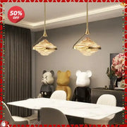 Two elegant gold led pendant lamps with textured cloud-like glass shades hang above a modern dining table