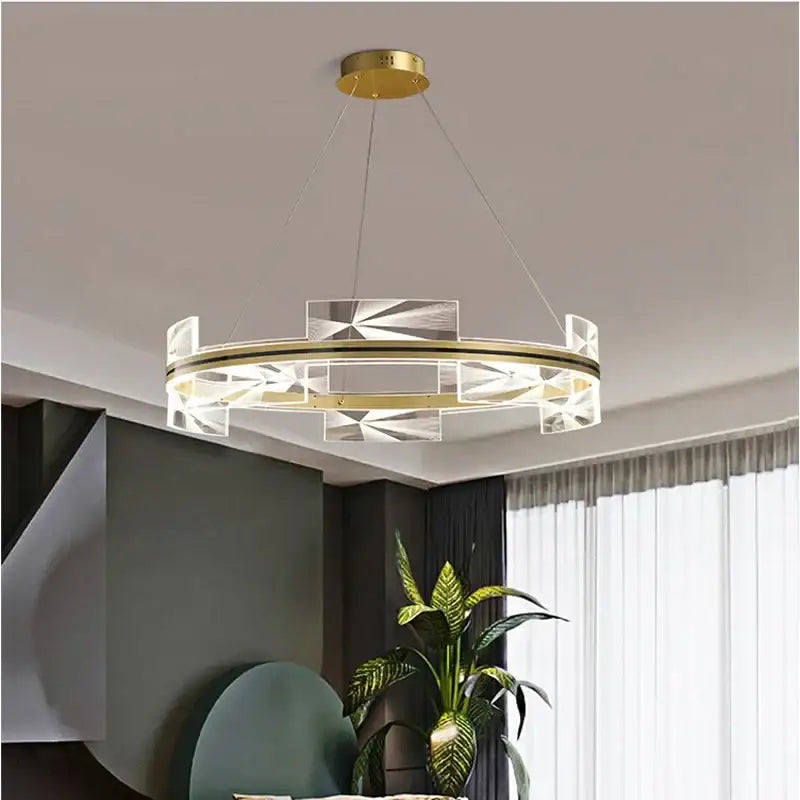 Modern gold led pendant lights featuring a circular chandelier with gold-toned metal frame and acrylic panels