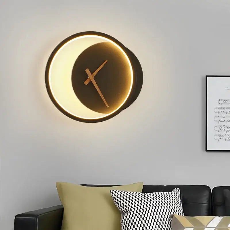 Modern gold led wall lamp clock with glowing rim, dark matte face, and minimalist wooden hands for living room lighting