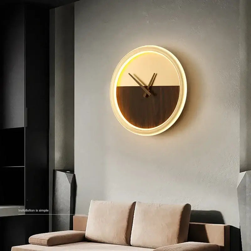 Modern gold led wall lamp clock with a two-tone cream and dark wood face, warm led glow, and metallic frame for living room