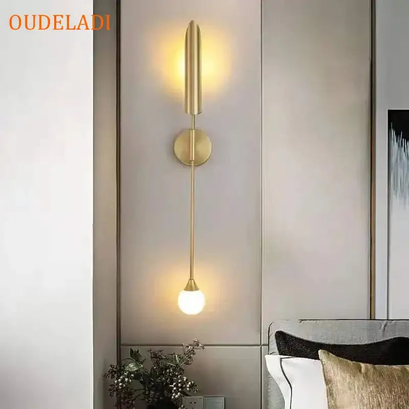 Modern gold led wall lamp with a sleek elongated design and spherical bulb for living room lighting