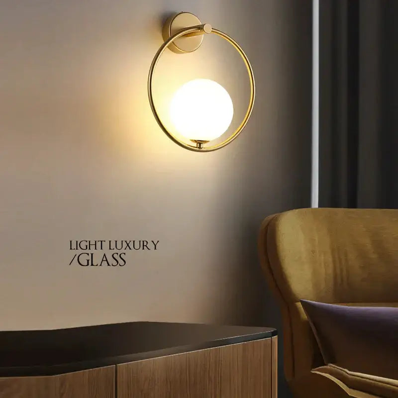 Modern gold led wall lamp featuring a circular design with frosted glass globe for living room lighting