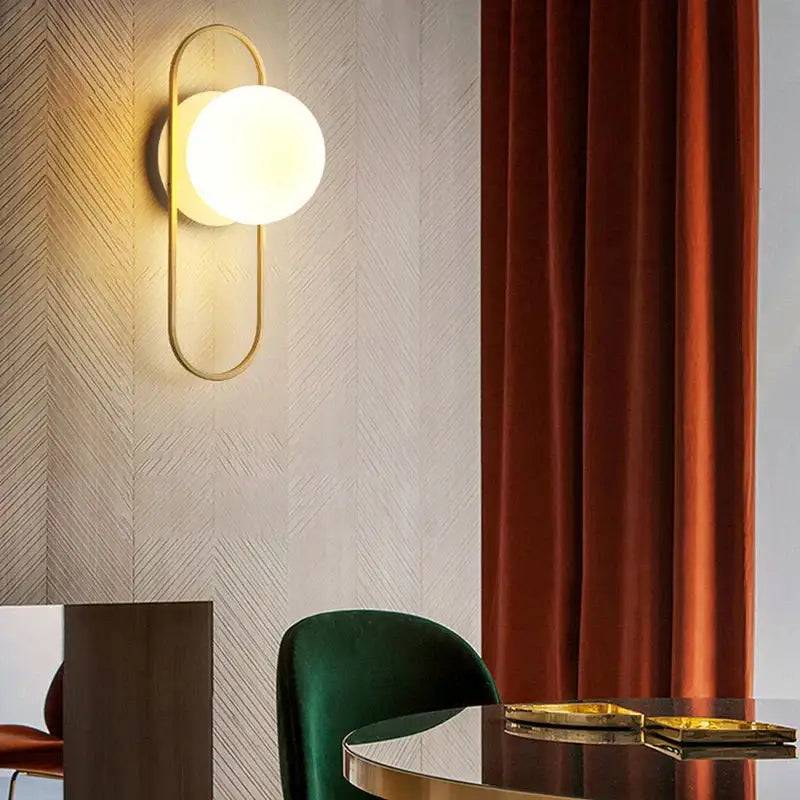 Modern gold led wall lamp featuring a gold-toned oval sconce with frosted glass globe for living room lighting