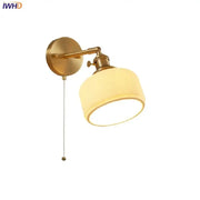 Modern gold led wall light with ribbed cream fabric shade and adjustable arm for bedroom reading use
