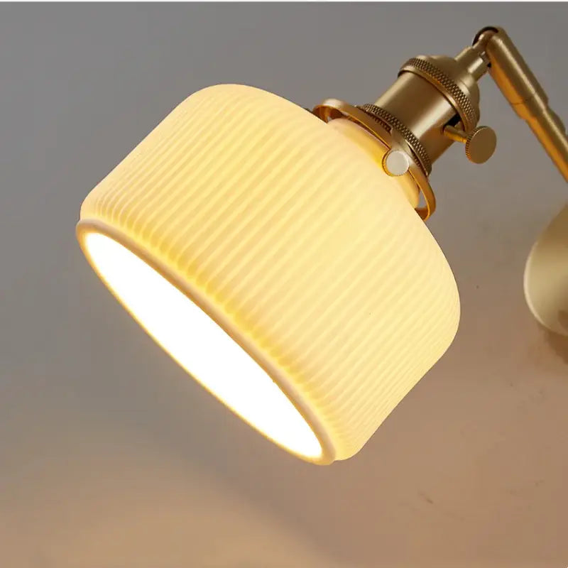 Modern gold led wall lights with warm-toned ribbed glass lampshade and brass-finished metal arm for bedroom reading