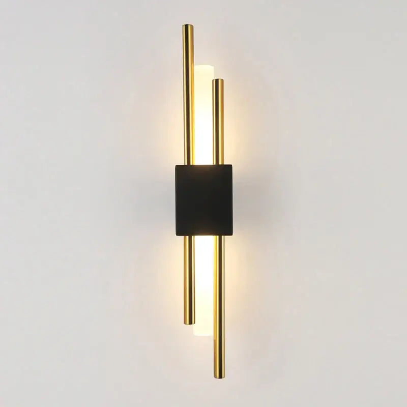 Modern gold led wall sconce with sleek black base and three vertical rods featuring an illuminated led wall sconce light