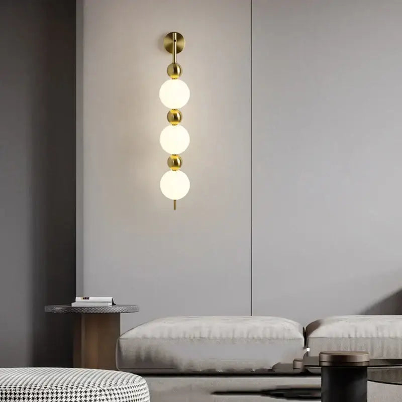 Modern gold led wall sconce with three frosted glass spheres and polished brass accents for bedroom decorbites led wall