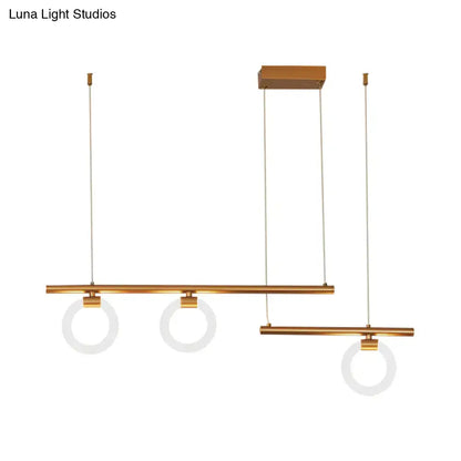 Modern brass-finished linear chandelier lamp with three circular frosted glass shades suspended by thin cables