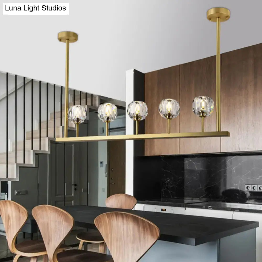Gold-toned DecorBites linear crystal ball pendant light with five clear crystal globe shades for dining rooms