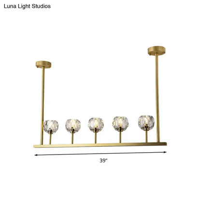 Gold-toned modern 5-head linear crystal ball pendant light fixture with faceted crystal globe shades for dining room