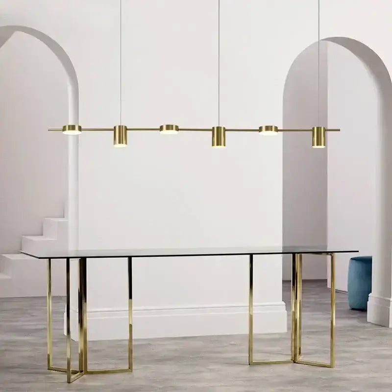 Modern gold linear dimmable led ceiling chandelier with five cylindrical bulbs above glass-top table decorbites dimmable led