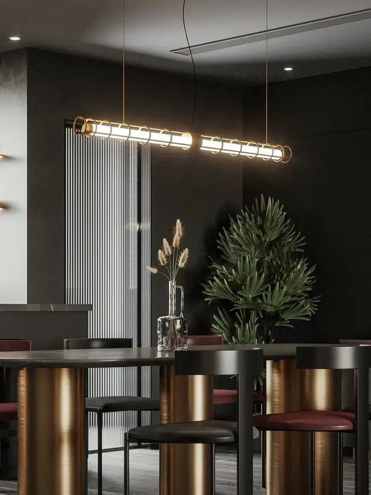 Modern gold linear glass chandelier pendant light with sleek cylindrical design and warm golden glow for dining room decorbites glass chandelier