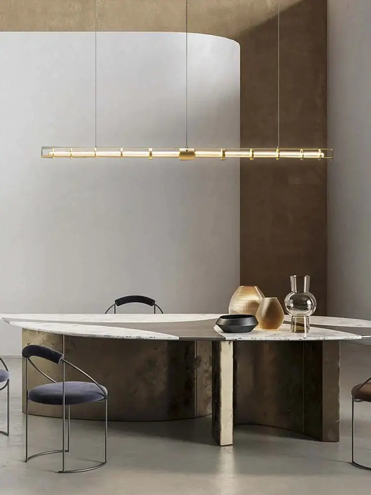 A modern gold linear glass dining room chandelier pendant light with gold metal frame and cylindrical led bulbs for decorbites glass dining