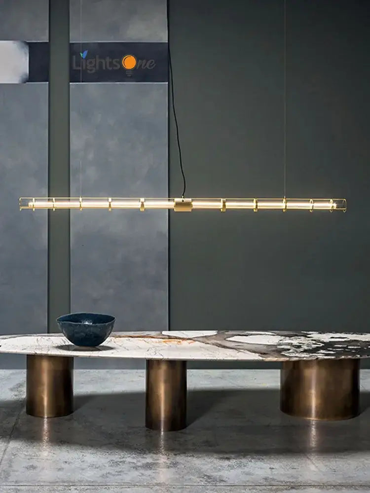 Modern gold linear glass dining room chandelier pendant light with sleek cylindrical segments and minimalist hanging cables
