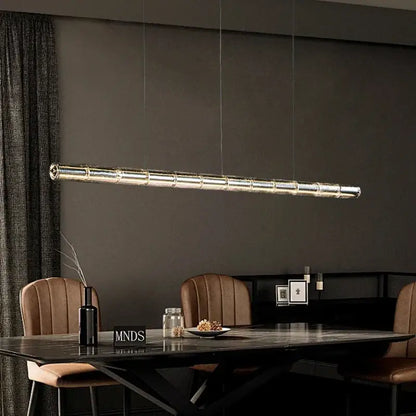 Modern gold linear glass led chandelier with segmented reflective glass panels suspended above kitchen island