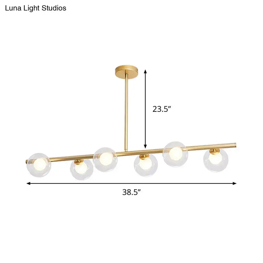 Modern gold linear island light with five clear glass globe shades and sleek horizontal island light fixture design