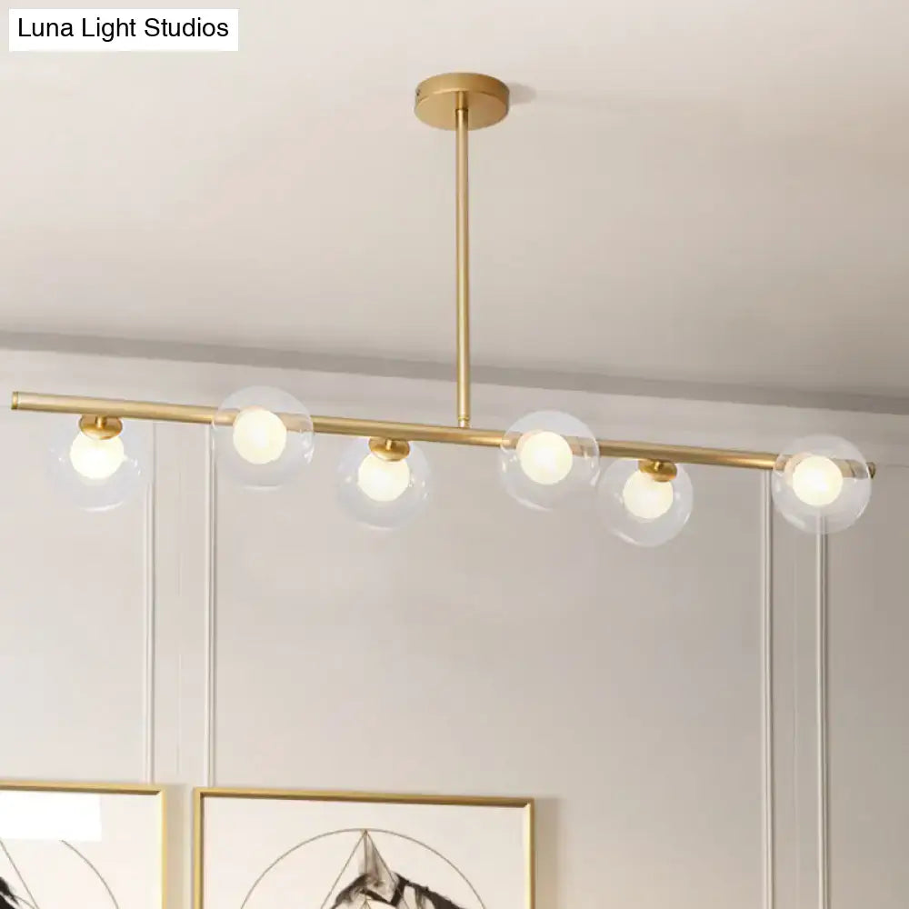 Modern gold linear island light with five clear glass globe shades for kitchen island light fixture