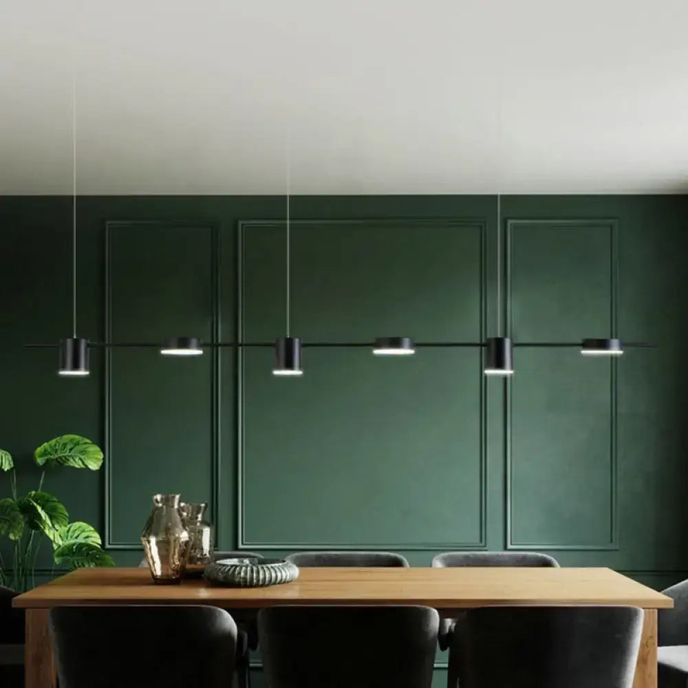 Modern black cylindrical led pendant light with sleek minimalist design in a linear shaped arrangement above dining table