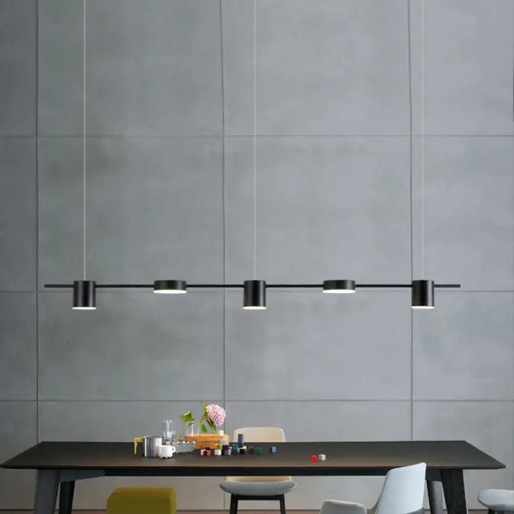 Black minimalist led pendant light with four cylindrical fixtures on a linear shaped bar for dining room use