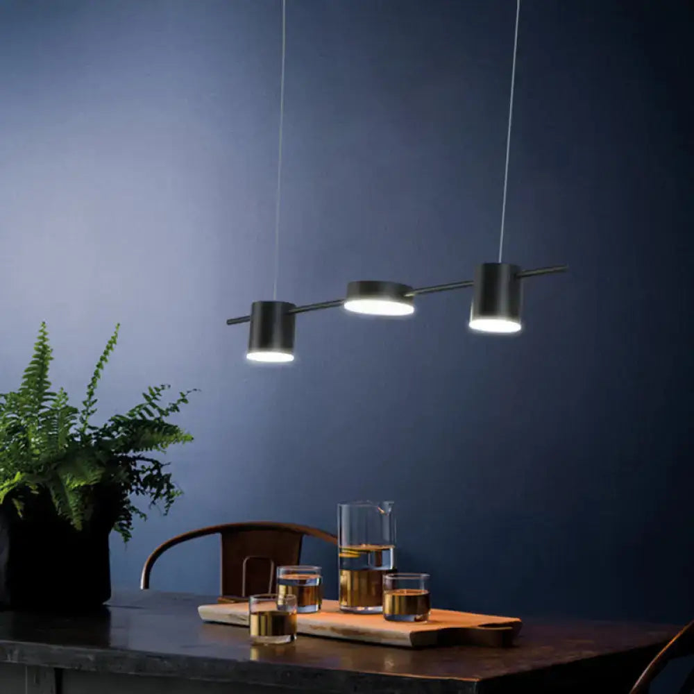 Modern black led pendant light with three cylindrical bulbs suspended by thin cords in a linear shaped design
