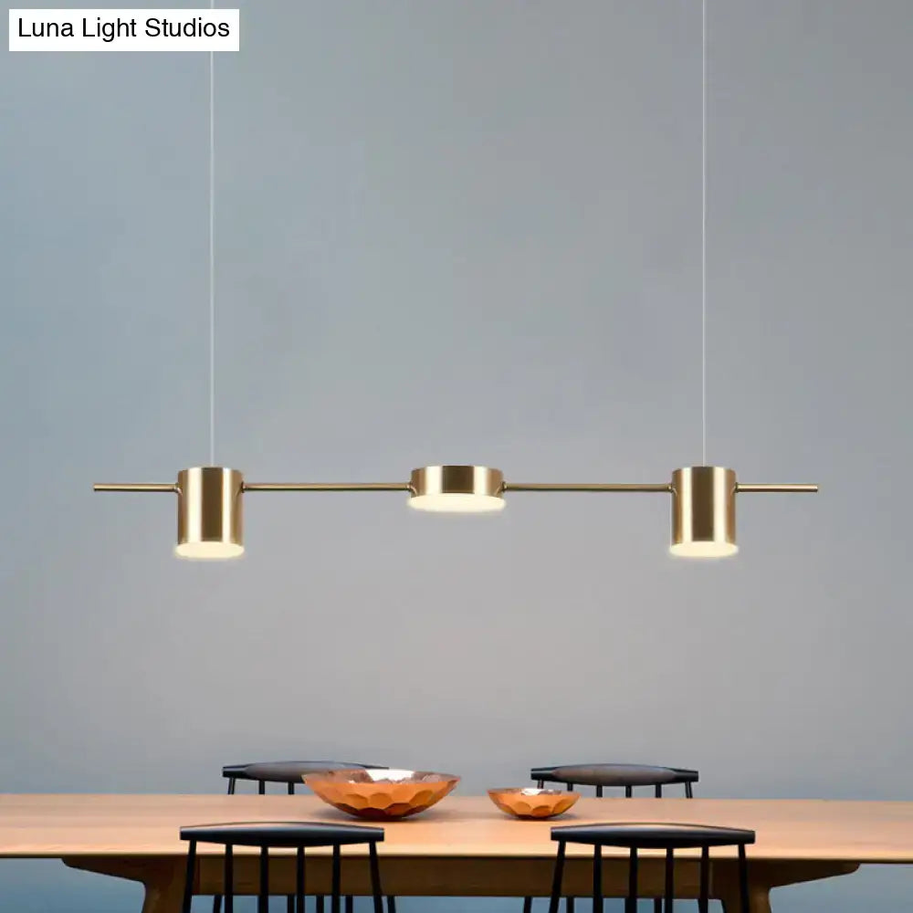 Modern gold linear shaped led pendant light with three brass cylindrical fixtures for dining room lighting