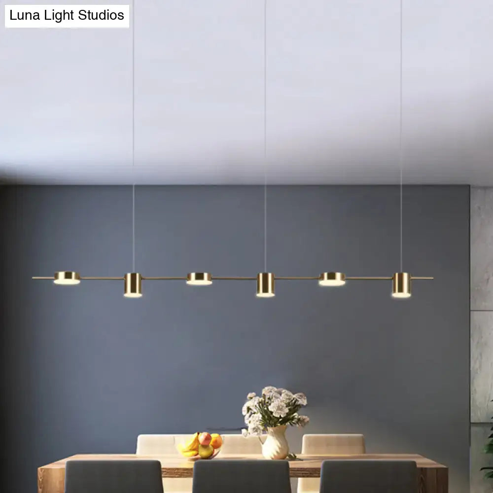Modern gold linear led pendant light with five cylindrical fixtures and thin cords for dining room lighting