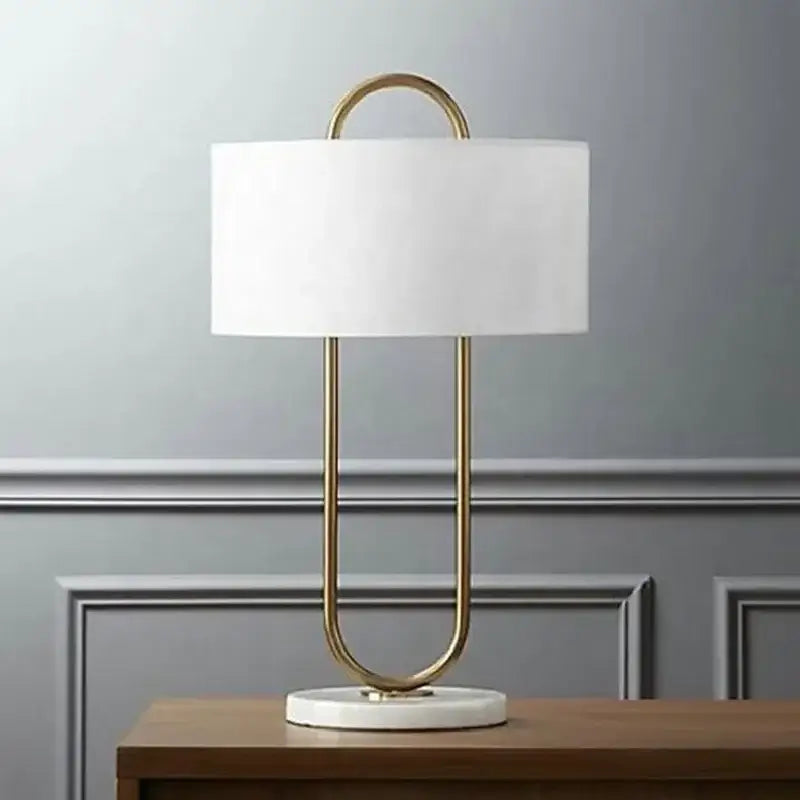 Modern gold luxury led table lamp with gold-toned paperclip design, white fabric shade, and marble base decorbites gold luxury