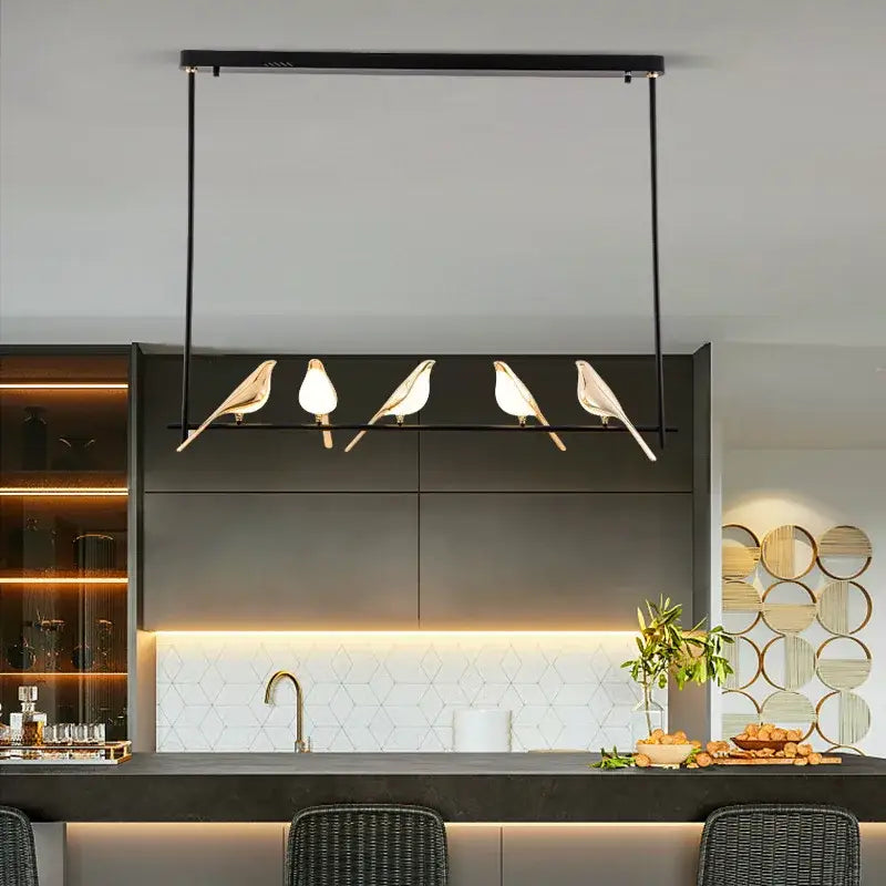 Modern black metal pendant light with four stylized white magpie bird bodies and gold-toned beaks for decorbites gold magpie ceiling decor