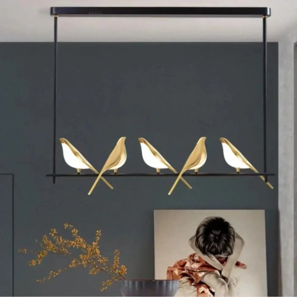 Modern gold magpie bird led chandelier featuring five golden minimalist pendants with white illuminated interiors for dining room decorbites gold magpie