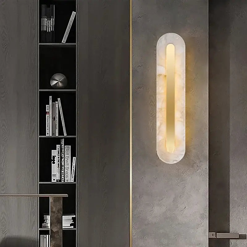A modern gold marble living room wall lamp with frosted glass and a warm amber glow encased in marble-like material