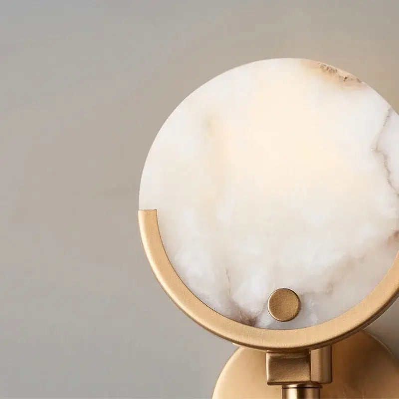 Modern gold marble wall lamp with off-white onyx shade framed by polished brass base decorbites gold marble copper