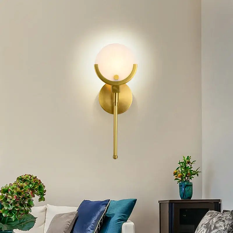 Gold-toned wall lights with frosted glass globe and curved metal arms for decorbites gold marble wall lighting