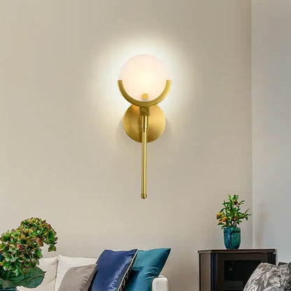 Gold-toned wall lights with frosted glass globe and curved metal arms for decorbites gold marble wall lighting