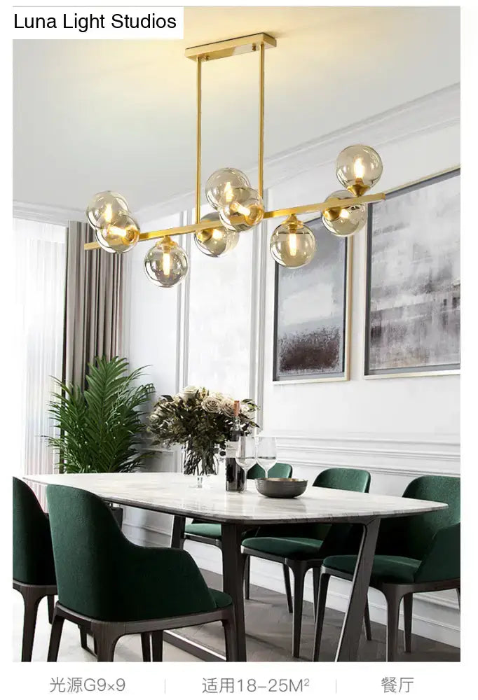Modern gold metal dining room island light with spherical amber glass globes and sleek metal frame