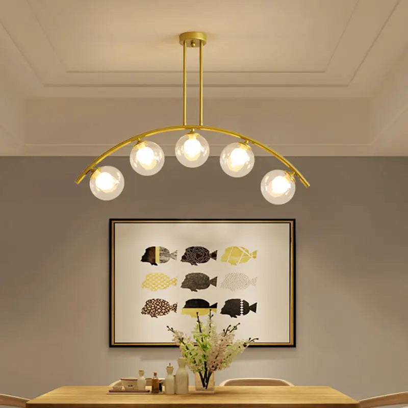 Modern gold metal arched ceiling light with five clear glass globe bulbs for dining room illumination
