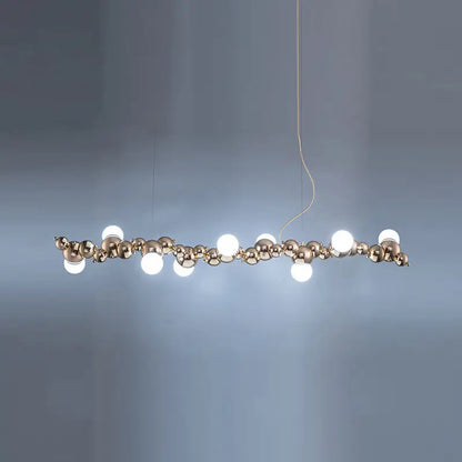 Modern gold metal arched ceiling light for dining room with six bulbs featuring polished brass spheres and white bulbs