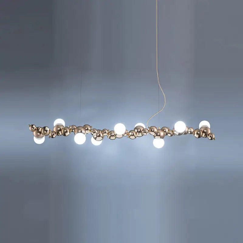 Modern gold metal arched ceiling light for dining room with six bulbs featuring polished brass spheres and white bulbs