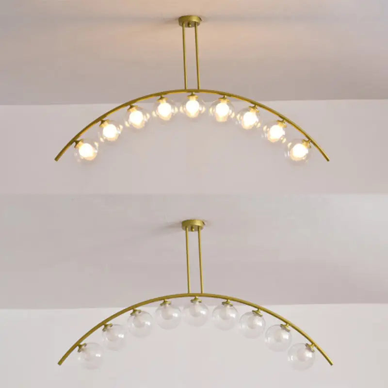 Modern gold metal arched ceiling light fixture with six clear glass globe bulbs for dining room use